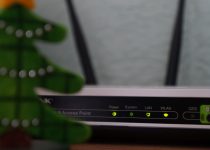 white and black modem router with four lights